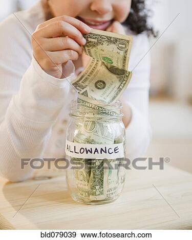 Hispanic girl putting allowance into jar View Large Photo Image Stock Photo - Hispanic girl putting allowance into jar. Fotosearch