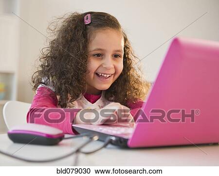 Stock Image - Hispanic girl using colorful laptop. Fotosearch