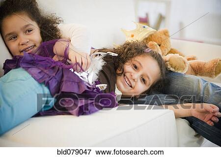 Hispanic sisters in costumes sleeping on couch View Large Photo Image Stock Photo - Hispanic sisters in costumes sleeping on couch. Fotosearch