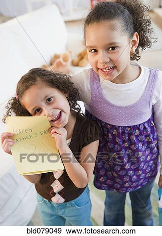 Hispanic sisters with Father's Day card View Large Photo Image Stock Photo - Hispanic sisters with Father's Day card. Fotosearch