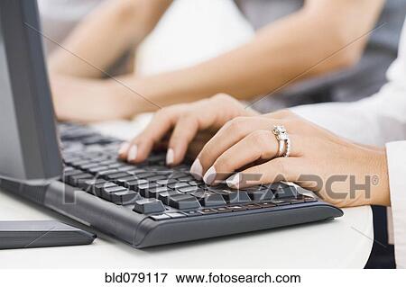 Stock Photo - Hispanic woman typing on keyboard. Fotosearch