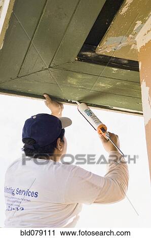 Latin man caulking roof eaves View Large Photo Image Stock Image - Latin man caulking roof eaves. Fotosearch
