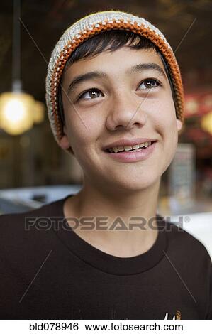 Stock Photograph - Mixed race boy in cap, smiling. Fotosearch