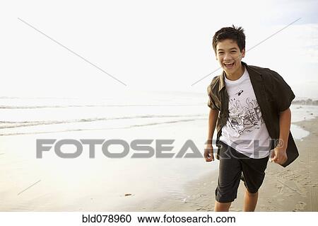 Mixed race boy laughing on beach View Large Photo Image Stock Image - Mixed race boy laughing on beach. Fotosearch