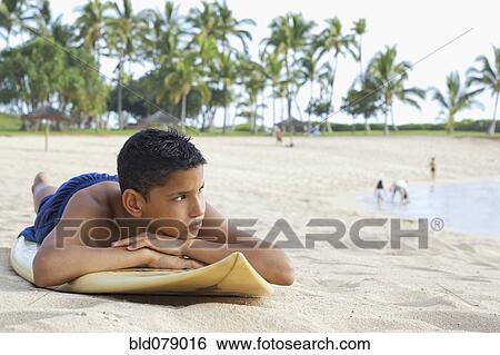 Mixed race boy on beach with surfboard View Large Photo Image Stock Photograph - Mixed race boy on beach with surfboard. Fotosearch