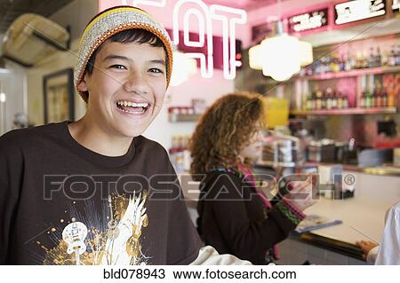 Stock Image - Mixed race boy smiling in cafe. Fotosearch