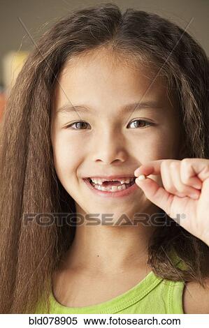 Mixed race girl holding toothy View Large Photo Image Stock Photography - Mixed race girl holding toothy. Fotosearch