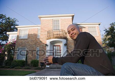 Mixed race man sitting outside home View Large Photo Image Stock Image - Mixed race man sitting outside home. Fotosearch