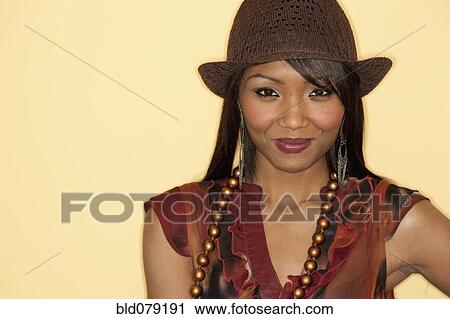 Stock Image - Mixed race woman in hat, smiling. Fotosearch