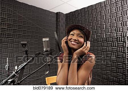 Stock Photo - Mixed race woman singing in recording studio. Fotosearch