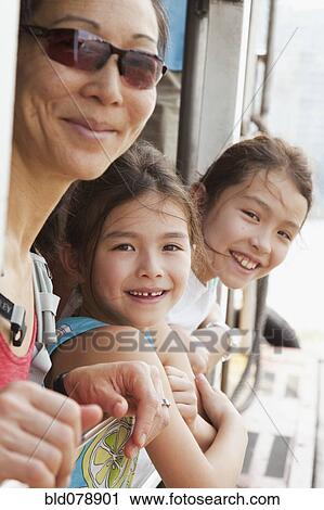 Stock Image - Mother and daughters riding on boat. Fotosearch