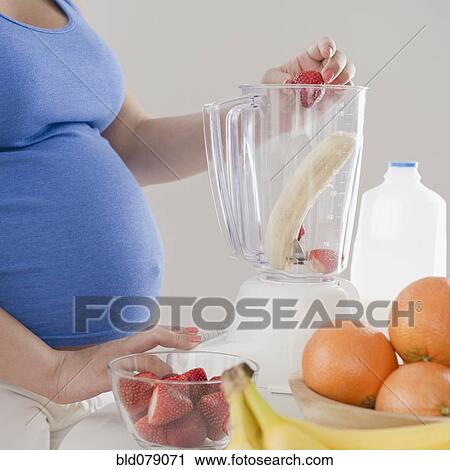 Pregnant Hispanic woman making fruit smoothie View Large Photo Image Stock Image - Pregnant Hispanic woman making fruit smoothie. Fotosearch