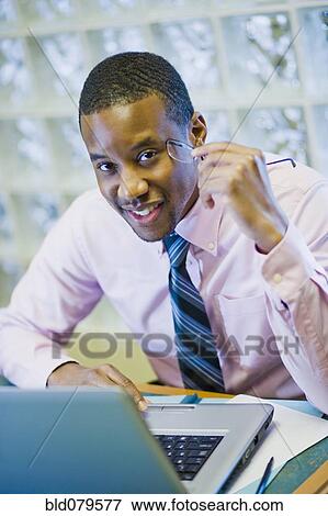 African American businessman sitting at desk View Large Photo Image Stock Photo - African American businessman sitting at desk. Fotosearch