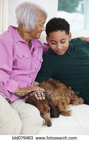 Stock Image - African American grandmother and grandson petting dog. Fotosearch