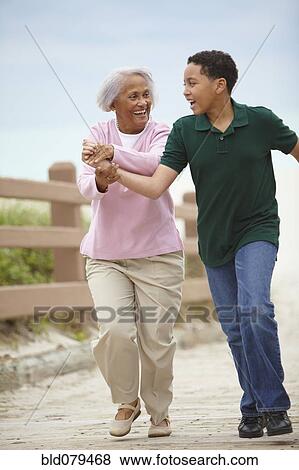 Stock Photo - African American grandmother and grandson running. Fotosearch