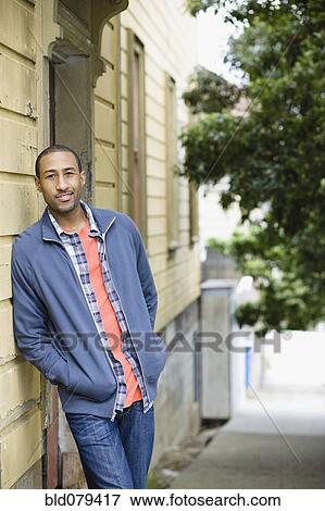 African American man leaning against side of building View Large Photo Image Stock Photo - African American man leaning against side of building. Fotosearch