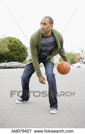 Stock Photo - African American man playing basketball. Fotosearch