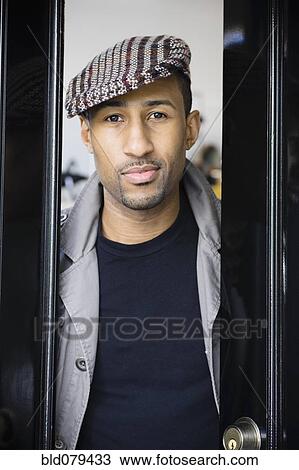 Stock Image - African American man wearing coat and cap. Fotosearch