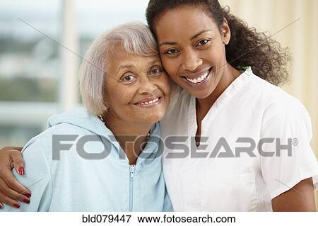 African American nurse hugging senior woman View Large Photo Image Stock Photo - African American nurse hugging senior woman. Fotosearch