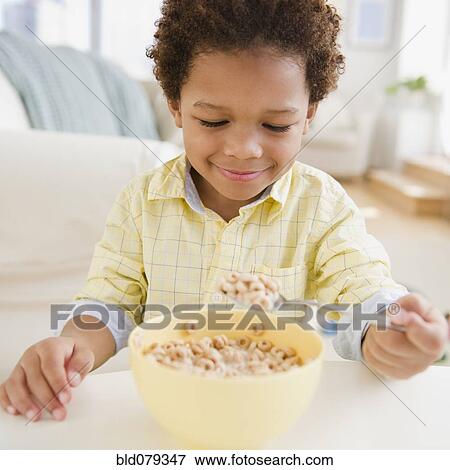 Stock Photo - Black boy eating bowl of cereal. Fotosearch