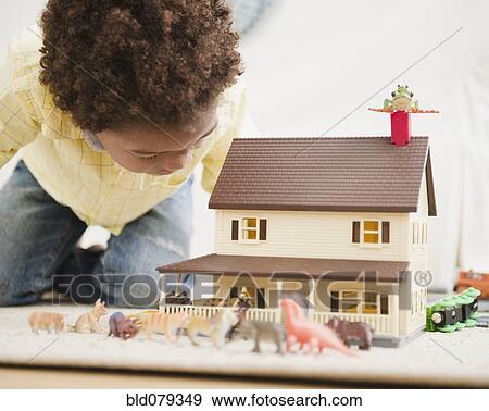 Black boy playing with toy house and animals View Large Photo Image Stock Photo - Black boy playing with toy house and animals. Fotosearch