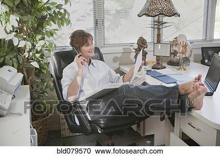 Stock Image - Caucasian businesswoman working in home office. Fotosearch