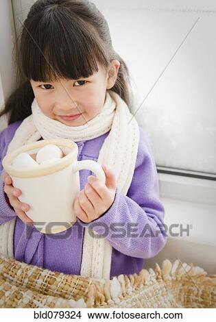 Picture - Chinese girl drinking hot chocolate. Fotosearch