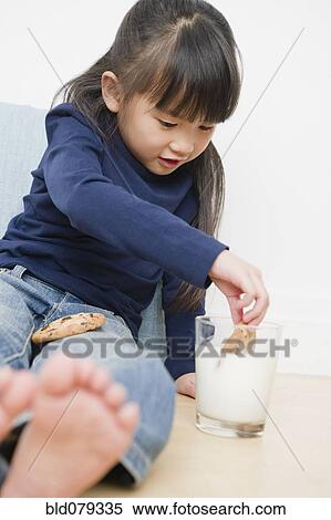 Chinese girl dunking cookies in milk View Large Photo Image Stock Photography - Chinese girl dunking cookies in milk. Fotosearch