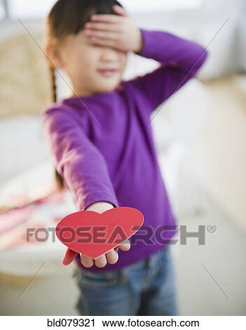 Stock Image - Chinese girl holding out Valentine. Fotosearch