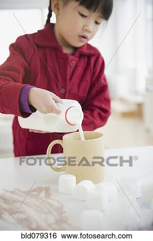 Stock Photograph - Chinese girl making hot chocolate. Fotosearch