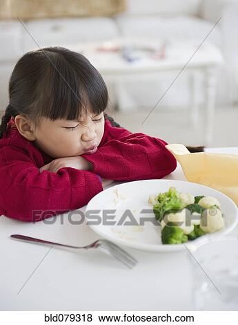 Stock Photo - Chinese girl refusing to eat vegetables. Fotosearch