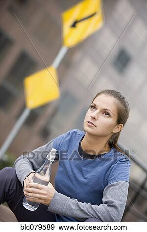 Hispanic woman drinking water in urban area View Large Photo Image Stock Photo - Hispanic woman drinking water in urban area. Fotosearch