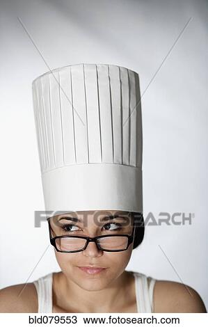 Stock Image - Hispanic woman in chef's hat and eyeglasses. Fotosearch