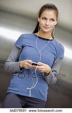 Hispanic woman listening to music on mp3 player View Large Photo Image Stock Image - Hispanic woman listening to music on mp3 player. Fotosearch