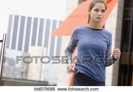Stock Photo - Hispanic woman running in urban area. Fotosearch