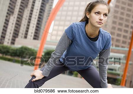 Stock Photograph - Hispanic woman stretching in urban area. Fotosearch