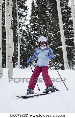 Stock Photo - Mixed race girl skiing in woods. Fotosearch