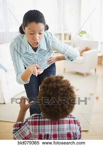 Stock Photography - Mixed race mother lecturing son. Fotosearch