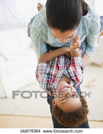 Picture - Mixed race mother playing with son. Fotosearch