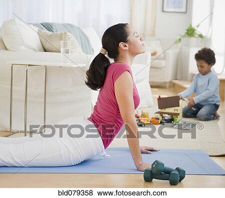 Mixed race mother practicing yoga View Large Photo Image Stock Photo - Mixed race mother practicing yoga. Fotosearch