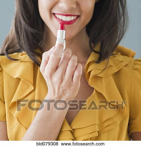 Mixed race woman applying lipstick View Large Photo Image Stock Photo - Mixed race woman applying lipstick. Fotosearch