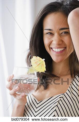 Mixed race woman drinking cocktail View Large Photo Image Picture - Mixed race woman drinking cocktail. Fotosearch