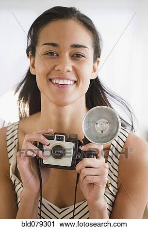 Mixed race woman holding old-fashioned camera View Large Photo Image Stock Image - Mixed race woman holding old-fashioned camera. Fotosearch