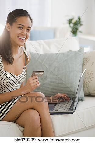 Stock Photo - Mixed race woman shopping online with credit card. Fotosearch