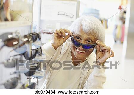Senior African American woman trying on sunglasses View Large Photo Image Picture - Senior African American woman trying on sunglasses. Fotosearch