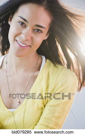 Stock Photography - Wind blowing mixed race woman's hair. Fotosearch