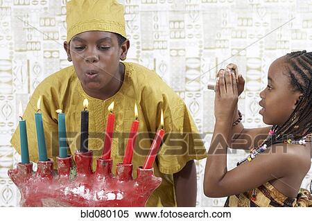 African American boy blowing out Kwanzaa candles View Large Photo Image Stock Photography - African American boy blowing out Kwanzaa candles. Fotosearch