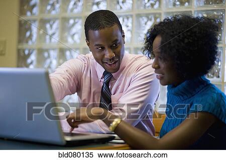 Stock Photography - African American businessman working with female co-worker. Fotosearch