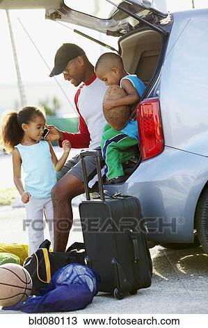 Stock Image - African American father holding cell phone for daughter. Fotosearch
