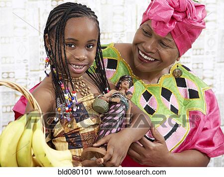 Stock Image - African American girl and grandmother in traditional clothing. Fotosearch